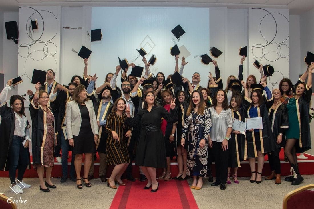 Une promotion de coachs certifiés lance ses chapeaux de diplômés lors de la cérémonie de remise des diplômes TO EVOLVE.